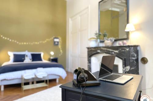 - une chambre avec un lit et un ordinateur portable sur un bureau dans l'établissement Le Crosne - Parking - Standing - Calme, à Rouen