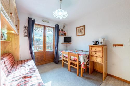 - une chambre avec un bureau, une table et une fenêtre dans l'établissement L’Écrin des Alpes - Studio au pied des pistes, à Praz-sur-Arly