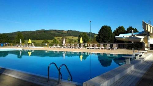 a large swimming pool with chairs and a boat at Chalet 3 étoiles - eeiid0 in Matour