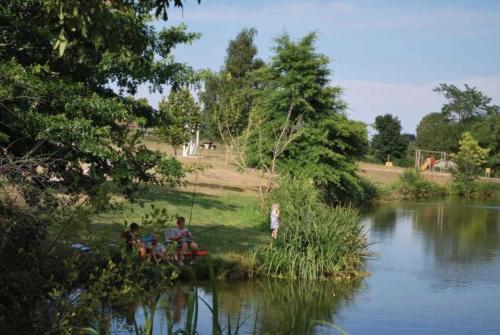 a group of people sitting by a river at Chalet 3 étoiles - eeiid0 in Matour