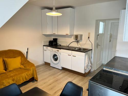 a kitchen and living room with a washer and dryer at FirmenQuartier24 Zülpich DG in Zülpich