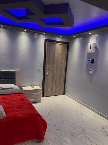 a bedroom with a red bed and a wooden door at MONASTHRIOY PALLAS 3 By MAKHOME in Thessaloniki