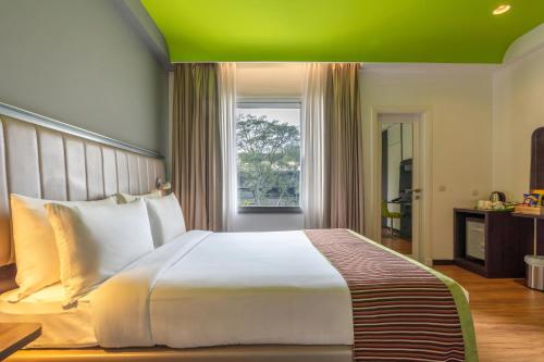 a bedroom with a large white bed and a window at Park Inn by Radisson,South Delhi in New Delhi