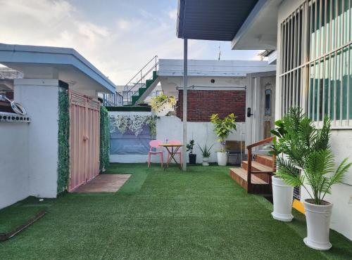 a small backyard with green grass and a table at Lucy Stay in Seoul