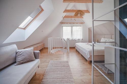 a attic bedroom with a bed and a couch at Tarninowe Wzgórze in Kunkowa