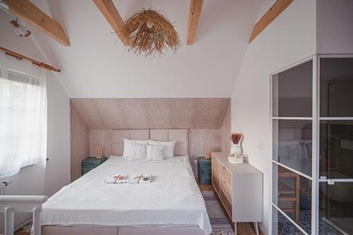 a bedroom with a large white bed with a window at Tarninowe Wzgórze in Kunkowa