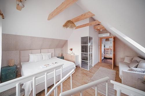 a bedroom with a white bed and a couch at Tarninowe Wzgórze in Kunkowa