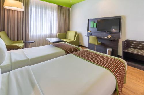 a hotel room with two beds and a tv at Park Inn by Radisson,South Delhi in New Delhi