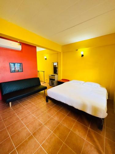 a bedroom with a bed and yellow and red walls at Moondance Cottage Inn in Ko Chang