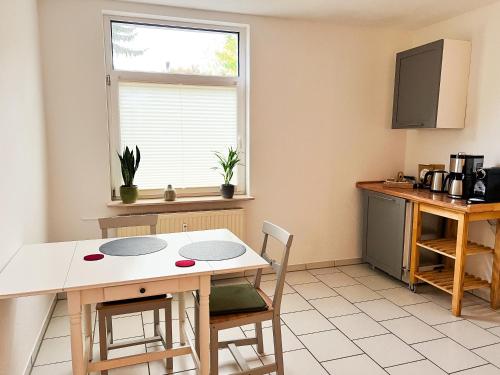 a kitchen with a table and chairs and a window at Qonroom - as individual as you - Wulferdingsen in Bad Oeynhausen