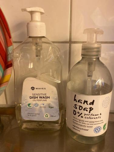 two bottles of laundry detergent sitting on a counter at Central cozy accommodation, single room or bed in dormroom in Gothenburg