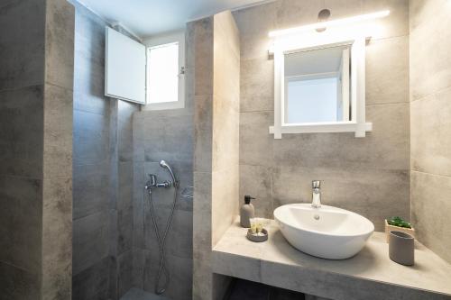 a bathroom with a sink and a shower at Vrachia Studios & Apartments in Oia