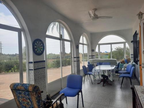 a room with chairs and a table and windows at Preciosa finca con piscina R105 by Novadesta in Elche