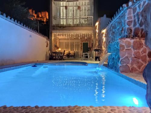 a swimming pool lit up in blue at night at Dharmia in Almodóvar del Río