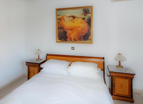 a bedroom with a white bed with two night stands at Corfu Aqua Nisaki in Nisakion