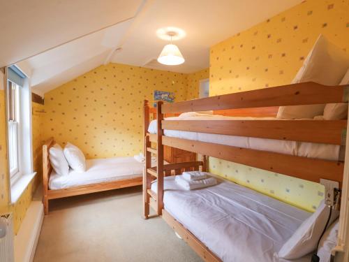 En eller flere senge i et værelse på Iona Cottage