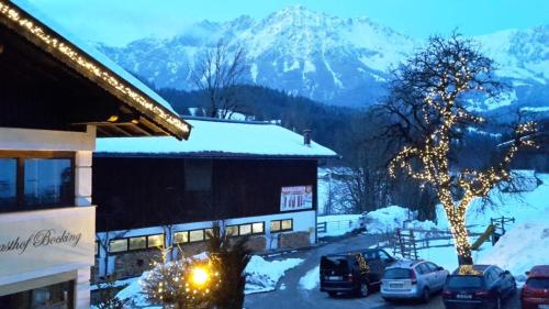 a snow covered mountain with cars parked in a parking lot at Gasthof Bocking in Söll