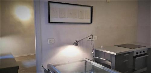 uma cozinha com um balcão e uma imagem na parede em Casa Milano - Apartments and Rooms - Duomo's Whisper em Milão