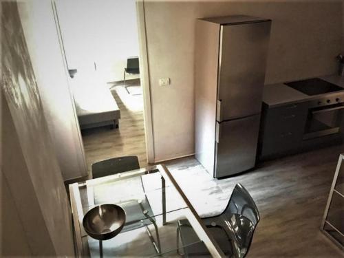 uma cozinha com uma mesa de vidro e um frigorífico em Casa Milano - Apartments and Rooms - Duomo's Whisper em Milão