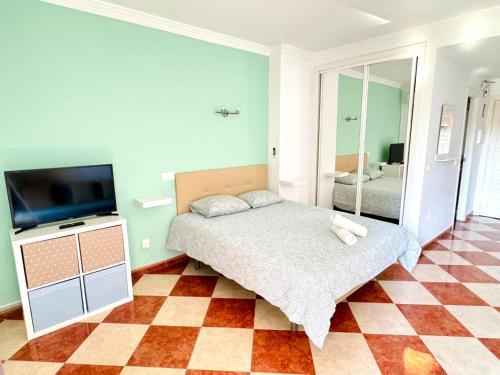 a bedroom with a bed and a flat screen tv at G&G Benalbeach Sea Views in Benalmádena