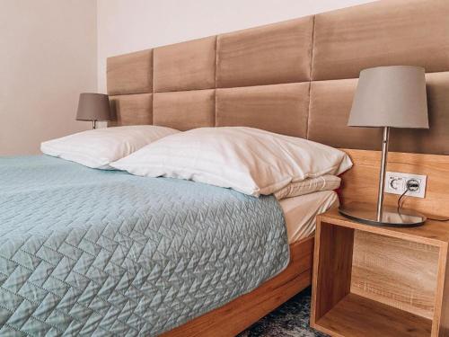 a bedroom with a bed with a large headboard at La Park Aparthotel in Kudowa-Zdrój