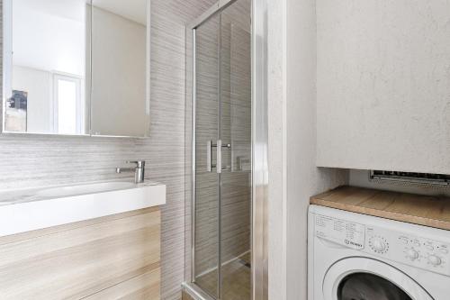 une salle de bain avec un lavabo et une machine à laver dans l'établissement Appartement de Charme 2BR Canal Saint Martin, à Paris