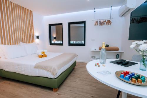 a bedroom with a bed and a table with a bowl of candy at Azores Smart Studios in Ponta Delgada