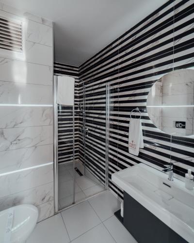 a white bathroom with a sink and a toilet at Fortunella Suites in Finike