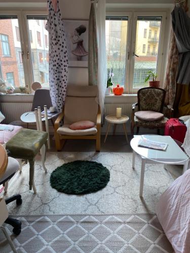 a living room with chairs and tables and windows at Central cozy accommodation, single room or bed in dormroom in Gothenburg
