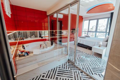 a bathroom with a tub and a red wall at Fortunella Suites in Finike