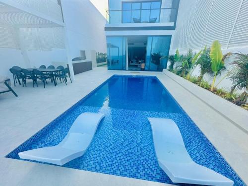 a swimming pool with two chairs and a house at 6BR SAZ Luxury Villa in Fujairah