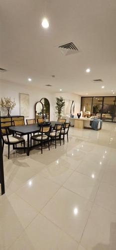a dining room with a table and chairs on a tile floor at 6BR SAZ Luxury Villa in Fujairah