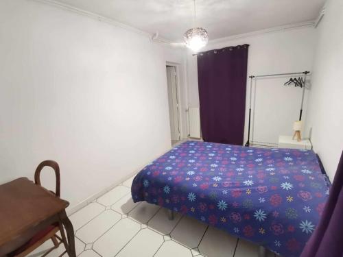 a bedroom with a blue bed in a white room at Location calme in Cournon-dʼAuvergne