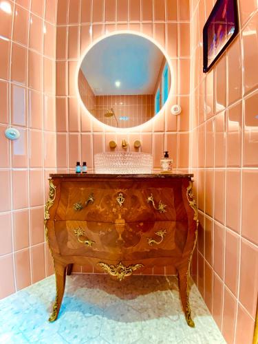 La salle de bains est pourvue d'une commode en bois et d'un miroir. dans l'établissement La Lizardière - Maison d'hôtes, à Montrichard