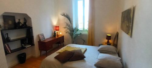 une chambre avec un lit, un bureau et une fenêtre dans l'établissement maison Rulman, à Nîmes