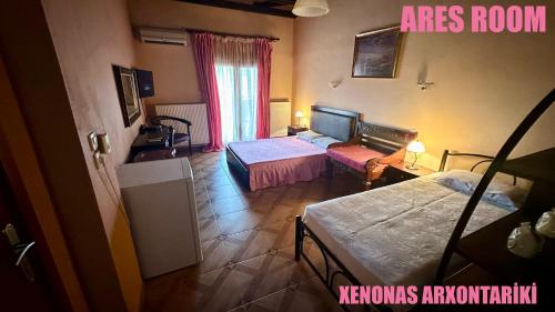 a hotel room with two beds and a living room with a room at Xenonas Arxontariki in Mikrón Dhérion