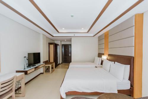 a hotel room with two beds and a television at Cebu Westown Lagoon - South Wing in Cebu City