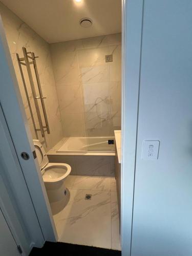 a bathroom with a toilet and a shower at Central Modern 3-Bedroom,3- Bathroom House with Patio and Carpark- Lower Hutt City Centre in Lower Hutt