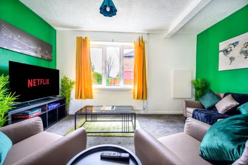 a living room with a couch and a tv at Trafford Eden - 3 Bed Home near Old Trafford and Trafford Centre with Free Parking in Manchester