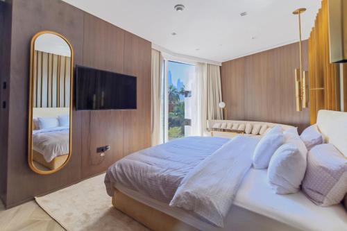 a bedroom with a large bed and a mirror at Luxury 3BDR Apartment, Pool & Beach Access in Dubai