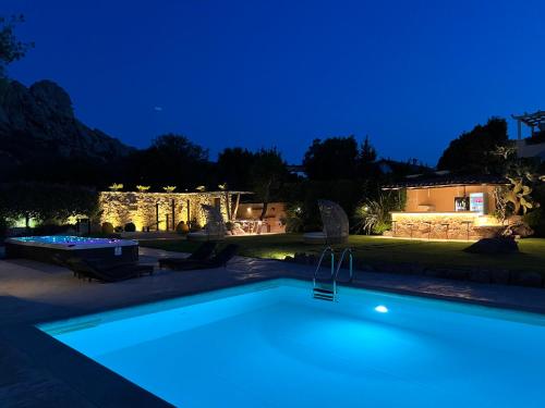 a swimming pool in a backyard at night at Antica Fonte Holiday Homes in San Pantaleo