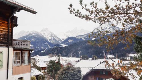 a view of a town with snow covered mountains at Sunshine Belle Etoile Chalet in Chateau-d'Oex