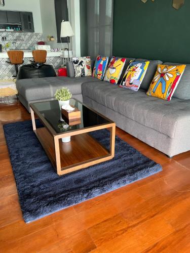 a living room with a couch and a coffee table at Talaytime Pool Villa in Laem Sing