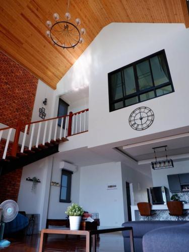 a living room with a staircase and a table at Talaytime Pool Villa in Laem Sing