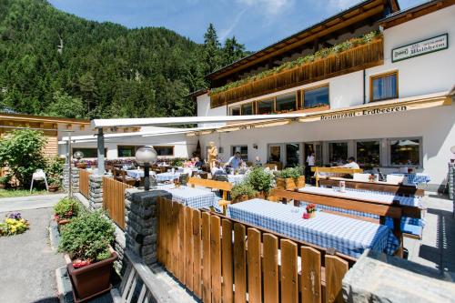 a restaurant with tables in front of a building at Hotel Restaurant Waldheim in Martello