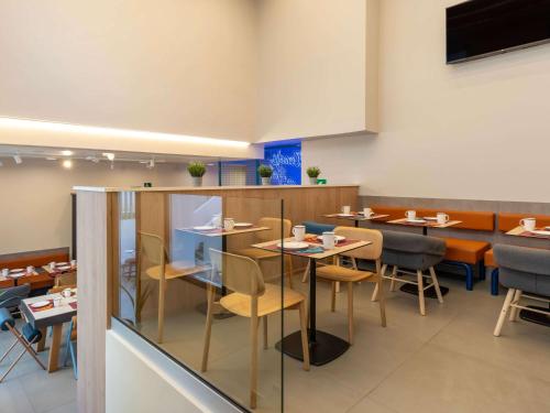 a dining room with tables and chairs in a restaurant at ibis budget Valencia Centro Puerto in Valencia