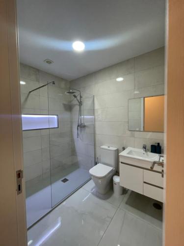 a bathroom with a shower and a toilet and a sink at Edificio Victor in Praia