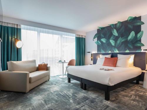 a hotel room with a bed and a couch at ibis Styles Bezons Paris La Défense in Bezons