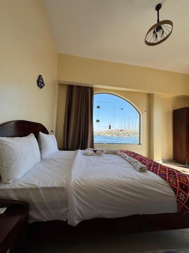 a bedroom with a large white bed with a window at DoroKa Nubian House in Aswan