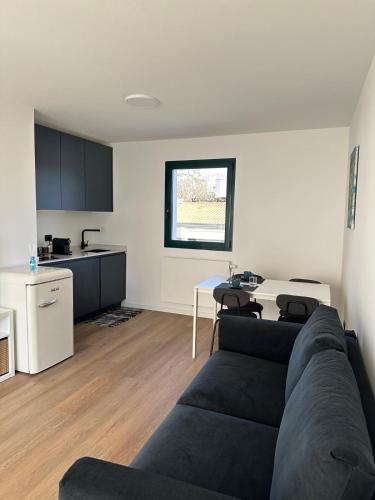 a living room with a black couch and a kitchen at Blue Suite in Latisana
